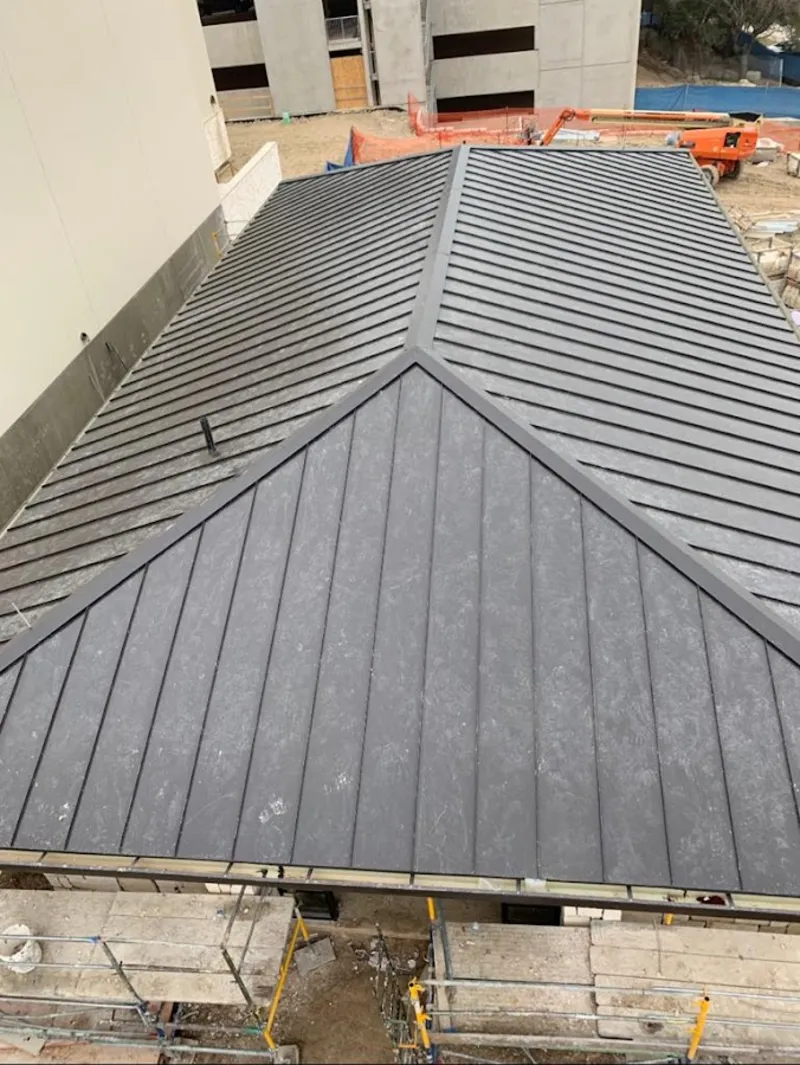 Commercial metal roof construction with crane equipment in Vinings